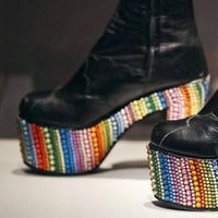 Sepatu vintage milik Elton John karya desainer Bill Whitten menjadi bagian dari koleksi pameran di Peabody Essex Museum, Salem, Massachusetts, AS, pada 2016. Gaya dengan sepatu seperti ini menjadi rujukan Ivan untuk penampilan yang ditegur KPI.  “Sepatu boots tinggi kayak cewek, @kpipusat jaman sekarang yag pake hak bukan cewek doang,” tulis Ivan di Instagram Stories. (Foto: AP Photo/Charles Krupa)