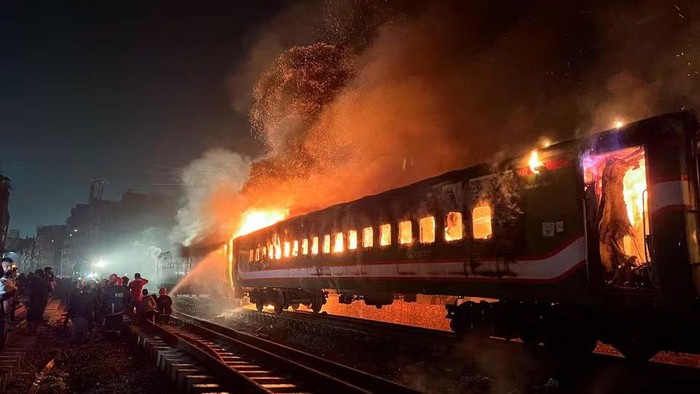 Firefighters try to extinguish a fire caught on a passenger train, ahead of the general election in Dhaka, Bangladesh, January 5, 2024. REUTERS/Mohammad Ponir Hossain CORRECTING INFORMATION FROM 