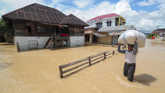 Warga menerobos genangan banjir luapan Sungai Batang Merao yang merendam kawasan permukiman di Koto Dian, Sungai Penuh, Jambi, Sabtu (6/1/2024).  Ratusan rumah di sepanjang aliran Batang Merao kota itu yang sempat surut pada Jumat (5/1) kembali terendam banjir hingga setinggi dada orang dewasa pada Sabtu (6/1) dini hari akibat tingginya intensitas hujan di daerah hulu. ANTARA FOTO/Wahdi Septiawan/nz