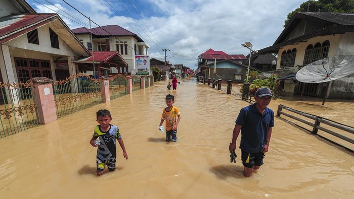 Warga menerobos genangan banjir luapan Sungai Batang Merao yang merendam kawasan permukiman di Koto Dian, Sungai Penuh, Jambi, Sabtu (6/1/2024).  Ratusan rumah di sepanjang aliran Batang Merao kota itu yang sempat surut pada Jumat (5/1) kembali terendam banjir hingga setinggi dada orang dewasa pada Sabtu (6/1) dini hari akibat tingginya intensitas hujan di daerah hulu. ANTARA FOTO/Wahdi Septiawan/nz