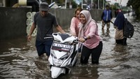 Tampak salah satu warga terpaksa harus mendorong motornya saat banjir.