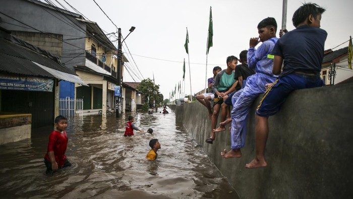 Sejumlah anak bermain saat terjadi banjir di Perumahan Pondok Maharta, Tangerang Selatan, Banten, Sabtu (6/1/2024). Banjir yang menggenangi permukiman warga tersebut disebabkan tingginya curah hujan serta sistem drainase yang buruk. ANTARA FOTO/Rivan Awal Lingga/tom.