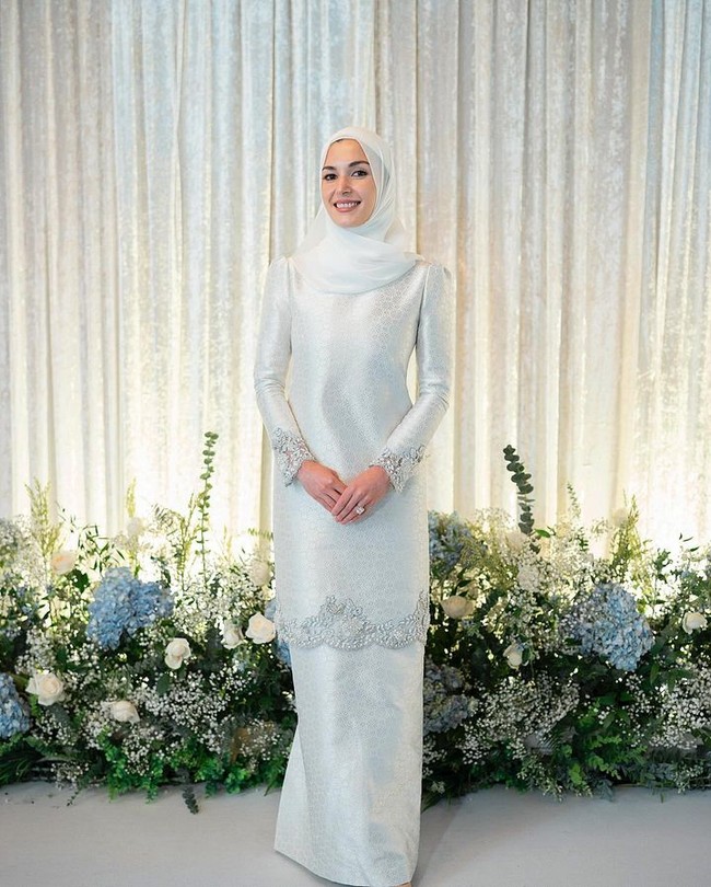 Rangkaian royal wedding Brunei kemudian berlanjut dengan Khatam Alquran. Ia memilih terusan bersiluet baju kurung tenun berwarna keperakan nan elegan rancangan desainer Malaysia Teh Firdaus untuk seremoni sakral tersebut. Hijab senada melengkapi gayanya. (Foto: Dok. Instagram @muash.portfolio)