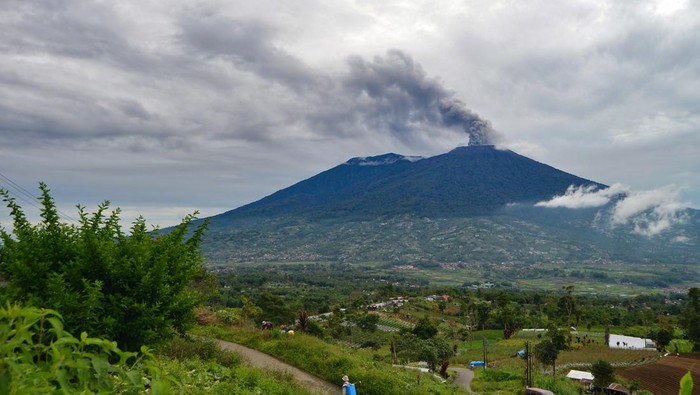 Warga berbincang saat Gunung Marapi mengeluarkan abu vulkanik yang terlihat dari kaki Gunung Singgalang, Nagari Pandai Sikek, Tanah Datar, Sumatera Barat, Minggu (7/1/2024). Gunung Marapi kembali erupsi pada awal tahun 2024 dan mengeluarkan suara gemuruh serta dentuman pada Sabtu (6/1/2024) malam. ANTARA FOTO/Iggoy el Fitra/aww.