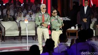 Ini momen saat Ganjar-Mahfud naik ke panggung di debat ke-3 Pilpres 2024. Keduanya sukses menjadi sorotan saat kompak mengenakan jaket bomber army dipadu dengan aksesoris berupa kacamata hitam.