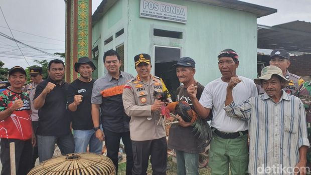 Kapolresta Pekanbaru Kombes Jeki Rahmat saat memberi bantuan ayam kampung ke seorang lansia tunawisma. (Raja Adil Siregar/detikSumut)