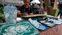Perajin menyelesaikan pesanan sandal ukir di Solo, Jawa Tengah, Minggu (7/1/2024).
