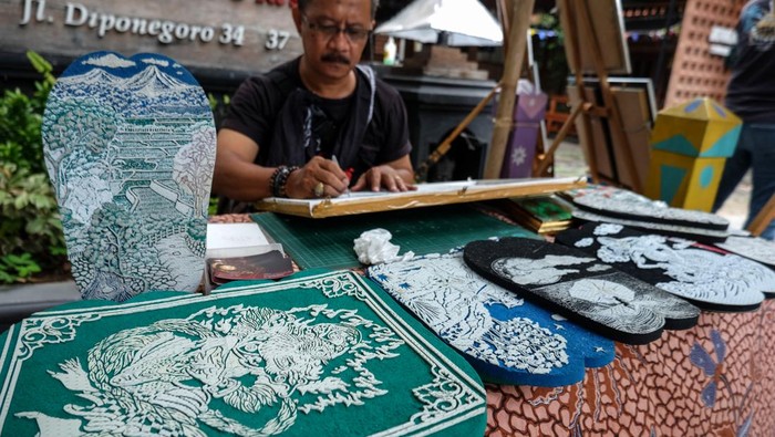 Perajin menyelesaikan pesanan sandal ukir di Solo, Jawa Tengah, Minggu (7/1/2024). Kerajinan sandal ukir produksi Sapit Uwos tersebut dijual seharga Rp35 ribu hingga Rp1 juta tergantung kerumitan gambar dan ukuran serta banyak diminati pembeli dari dalam negeri maupun mancanegara lewat pemasaran daring. ANTARAFOTO/Maulana Surya/aww.