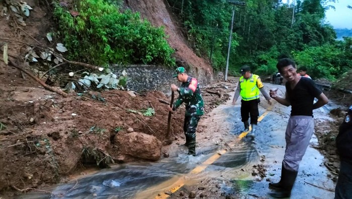 Anggota TNI Kodim 0405 Lahat  membantu membersihkan jalan bekas longsor