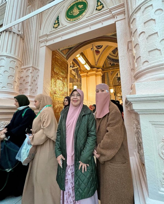 Wanita kelahiran 22 Maret 1983 ini terlihat mengunggah kegiatannya selama umrah. Salah satunya saat mengabadikan momen bersama sang ibunda, Emmy Sjarif, ketika berada di Masjid Nabawi, Madinah. BCL terlihat memakai cadar warna pastel pink dan long coat. Sedangkan ibunya memakai long coat hijau tua bahan parasut dan khimar warna pink. Foto: Dok. Instagram @itsmebcl.