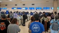 Penumpang mencoba memesan ulang tiket mereka dari penerbangan United Airlines di Bandara Internasional Luis Munoz Marin, San Juan, Puerto Rico, Minggu (7/1/2024). (REUTERS/Miguel J. Rodriguez Carrillo)