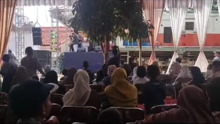 Kereta melintas melewati hajatan warga di Cilacap, Selasa (2/1/2024).