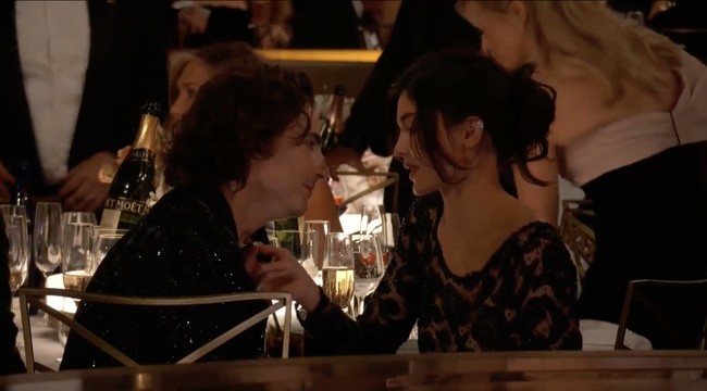 Kylie Jenner tampak menyentuh kalung yang dipakai sang kekasih Timothee Chalamet. Bintang film Wonka itu pun menatap mesra Kylie. Foto: dok. AFP