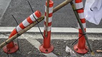 APK tersebut dipasang di tiang pembatas jalur sepeda menggunakan kabel tis.
