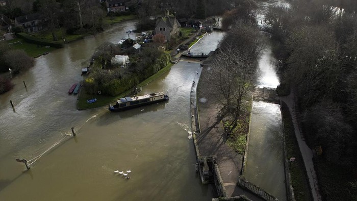A narrow boat sits in the floods of the river Thames in Oxford, England, Sunday, Jan. 7, 2024. Britain was hit by heavy rainfall last week following storm Henk, which led to flooding in parts of the UK. (AP Photo/Frank Augstein)