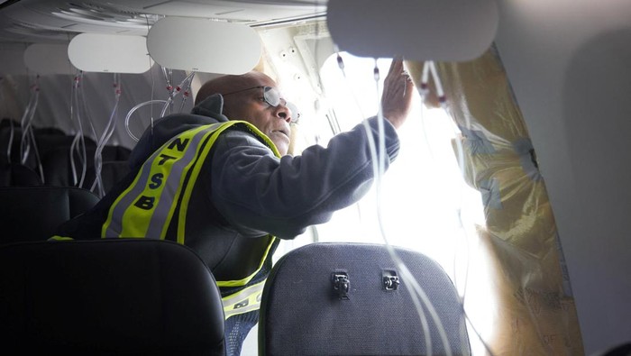 National Transportation Safety Board (NTSB) Investigator-in-Charge John Lovell examines the fuselage plug area of Alaska Airlines Flight 1282 Boeing 737-9 MAX, which was forced to make an emergency landing with a gap in the fuselage, in Portland, Oregon, U.S. January 7, 2024.  NTSB/Handout via REUTERS.   THIS IMAGE HAS BEEN SUPPLIED BY A THIRD PARTY
