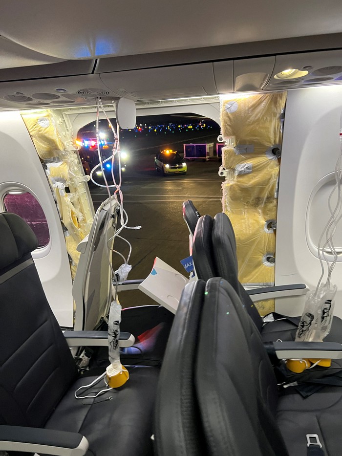 Passenger oxygen masks hang from the roof next to a missing window and a portion of a side wall of an Alaska Airlines Flight 1282, which had been bound for Ontario, California and suffered depressurization soon after departing, in Portland, Oregon, U.S., January 5, 2024 in this picture obtained from social media. Instagram/@strawberrvy via REUTERS  THIS IMAGE HAS BEEN SUPPLIED BY A THIRD PARTY. MANDATORY CREDIT.