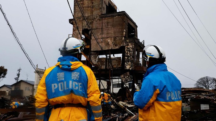 Pencarian Korban Gempa Jepang Terus Dilakukan Policemen work in Asaichi-dori street, which burned down due to a fire following an earthquake in Wajima, Ishikawa Prefecture, Japan, January 7, 2024. REUTERS/Kim Kyung-Hoon