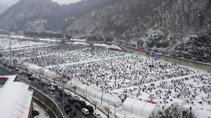 Participants cast lines through holes drilled in the surface of a frozen river during a trout catching contest in Hwacheon, South Korea, Saturday, Jan. 6, 2024. The contest is part of an annual ice festival which draws over one million visitors every year. (AP Photo/Ahn Young-joon)