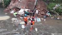 Petugas BPBD setempat mendatangi lokasi rumah longsor di Sungai Kasin, Kota Malang.