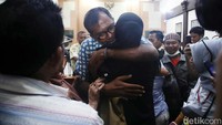 Haris Azhar memeluk keluarganya usai vonis bebas.  