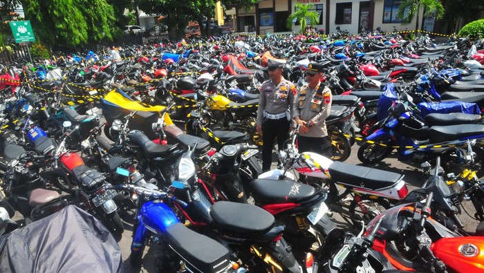 Polisi memasang garis polisi di sekitar sepeda motor berknalpot brong sitaan di Polsek Kota, Kudus, Jawa Tengah, Selasa (9/1/2024). Satlantas Polres Kudus berhasil menyita sebanyak 700 lebih sepeda motor dengan knalpot brong selama 1-9 Januari 2024 sebagai langkah meminimalisir  penggunakan knalpot brong saat kampanye terbuka Pemilu yang mengganggu kenyamanan masyarakat. ANTARA FOTO/Yusuf Nugroho/rwa.