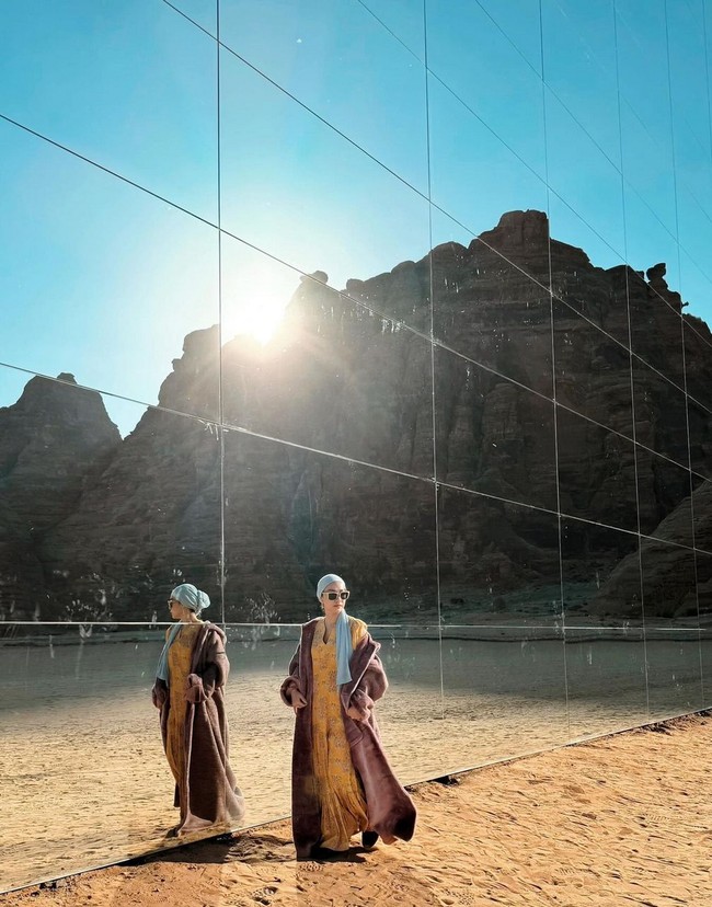 Mengenakan gaun dan mantel bernuansa coklat dilengkapi turban, BCL mengabadikan momen saat foto di depan Maraya Concert Hall, sebuah bangunan kaca raksasa di kawasan tersebut. Foto: Instagram