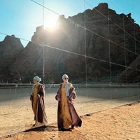 Mengenakan gaun dan mantel bernuansa coklat dilengkapi turban, BCL mengabadikan momen saat foto di depan Maraya Concert Hall, sebuah bangunan kaca raksasa di kawasan tersebut. Foto: Instagram