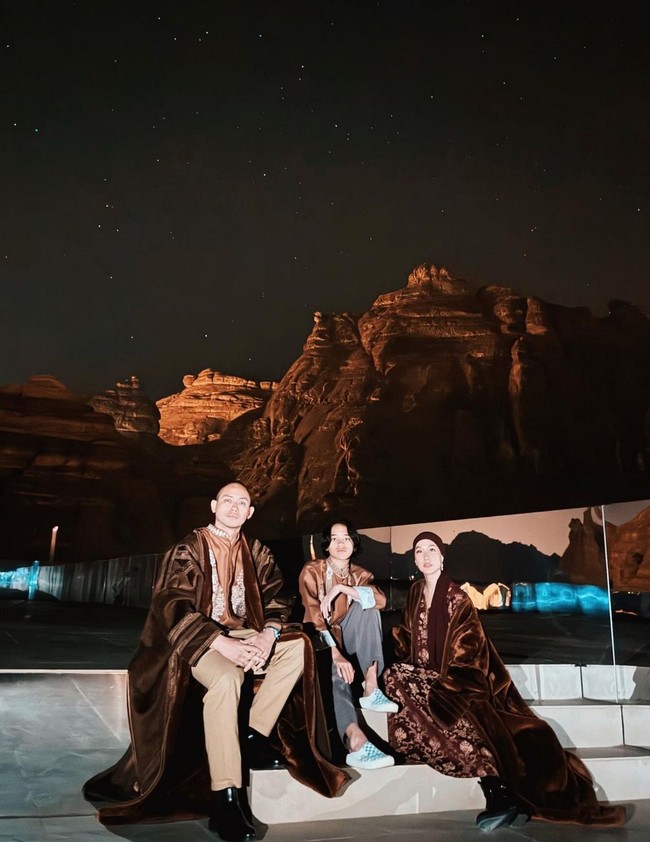 Setelah menjalankan ibadah umrah, Bunga Citra Lestari (BCL) menyempatkan berkunjung ke Al Ula bersama anaknya, Noah, dan suami Tiko Aryawardhana. Mereka berpose dengan latar belakang perbukitan batu. Foto: Instagram