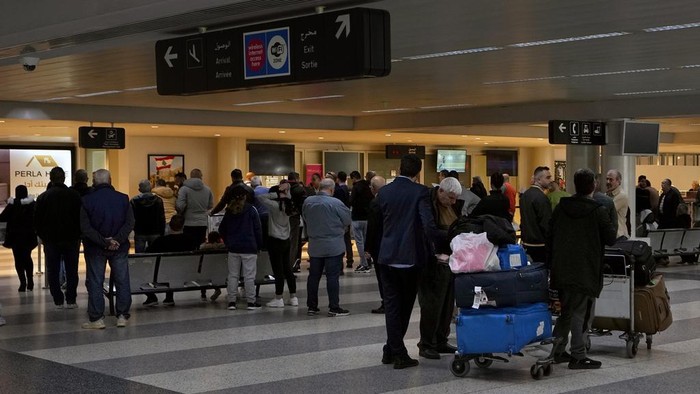 Travelers push their luggage at the departure terminal of the Rafik Hariri International Airport in Beirut, Lebanon, Monday, Jan. 8, 2024. The information display screens on Sunday at Beirut's international airport were hacked by domestic anti-Hezbollah groups, as clashes between the Lebanese militant group and the Israeli military continue to intensify along the border. Departure and arrival information Sunday was replaced by a message accusing the Hezbollah group of putting Lebanon at risk of an all-out war with Israel. (AP Photo/Bilal Hussein)
