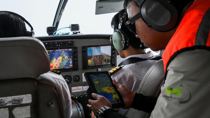 BNPB modifikasi cuaca di Jabodetabek Petugas berkoordinasi dengan pilot menentukan titik operasi teknologi modifikasi cuaca di dalam pesawat Cessna Caravan saat berada di langit wilayah Ujung Kulon, Banten, Selasa (9/1/2024). BNPB bersama BMKG dan BRIN melakukan operasi teknologi modifikasi cuaca sebagai upaya meminimalisir berkumpulnya awan yang berpotensi menimbulkan intensitas hujan tinggi terjadi di sejumlah wilayah Jabodetabek yang rawan terkena bencana hidrometeorologi. ANTARA FOTO/Sulthony Hasanuddin.