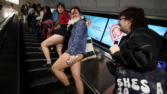 A woman poses as she travels on the London Underground during the 