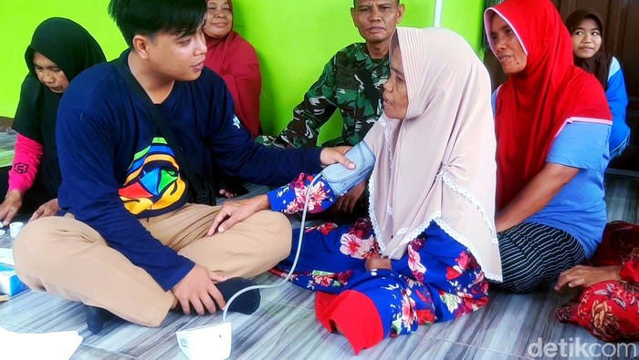 Petugas kesetahan saat mengobati warga korban bencana banjir di posko pengungsian Kantor Desa Karangligar Karawang.