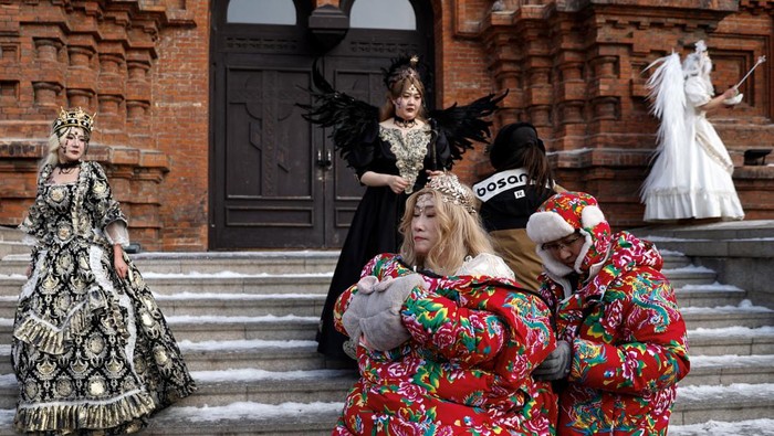 A woman dressed up in costume poses for pictures during a photo shoot, in front of the Saint Sophia Cathedral in Harbin, Heilongjiang province, China January 5, 2024. REUTERS/Tingshu Wang
