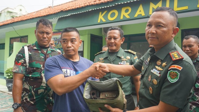 Didin Muhyidin saat serahkan senpi ke TNI.