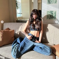 Pelantun ‘Kitsch’ itu berpose di depan jendela dengan pemandangan gedung pencakar langit. Sinar matahari membuat garis otot perutnya semakin jelas. Foto: dok. Instagram @for_everyoung10