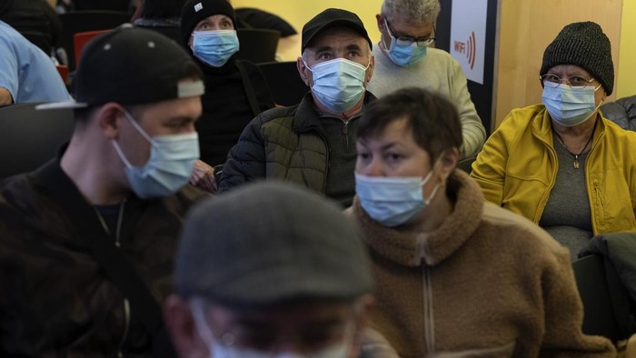 People wearing face masks as a precaution wait for a doctor appointment inside a hospital in Barcelona, Spain, Monday, Jan. 8, 2024. Regional and national health chiefs are meeting Monday to decide whether to extend mandatory mask—wearing to all health facilities following an epidemic outbreak of flu and other respiratory viruses that are putting a strain on the system. (AP Photo/Emilio Morenatti)