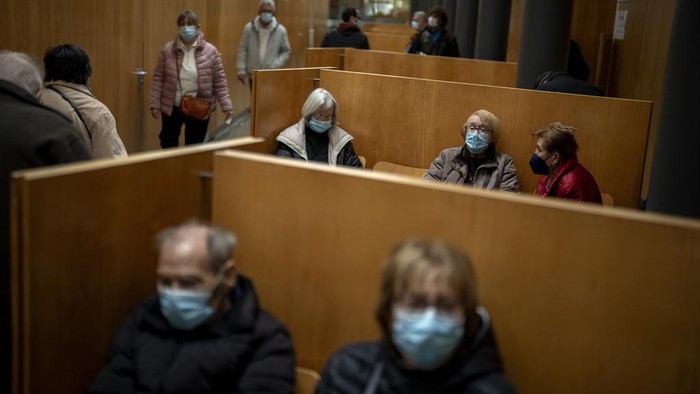 People wearing face masks as a precaution wait for a doctor appointment inside a hospital in Barcelona, Spain, Monday, Jan. 8, 2024. Regional and national health chiefs are meeting Monday to decide whether to extend mandatory mask—wearing to all health facilities following an epidemic outbreak of flu and other respiratory viruses that are putting a strain on the system. (AP Photo/Emilio Morenatti)