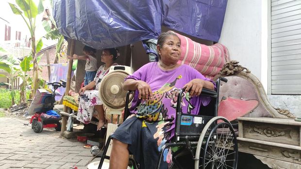 Khuzaimah didepan rumahnya yang tidak layak huni