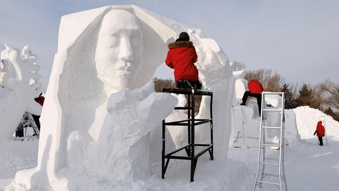 Artists from South Korea work on a snow sculpture during a contest, at the Harbin International Ice and Snow Festival, at the Sun Island Park in Harbin, Heilongjiang province, China January 8, 2024. REUTERS/Tingshu Wang