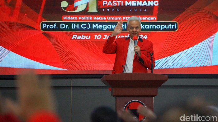 Capres Ganjar Pranowo berpidato di acara HUT PDIP. Ganjar memakai jas merah berbicara di hadapan undangan.