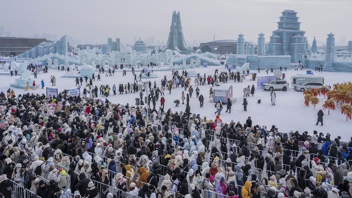 In this photo released by Xinhua News Agency, tourists line up for a ride on an ice slide at the Harbin Ice-Snow World in Harbin in northeastern China's Heilongjiang Province on Jan. 1, 2024. (Xie Jianfei/Xinhua via AP)