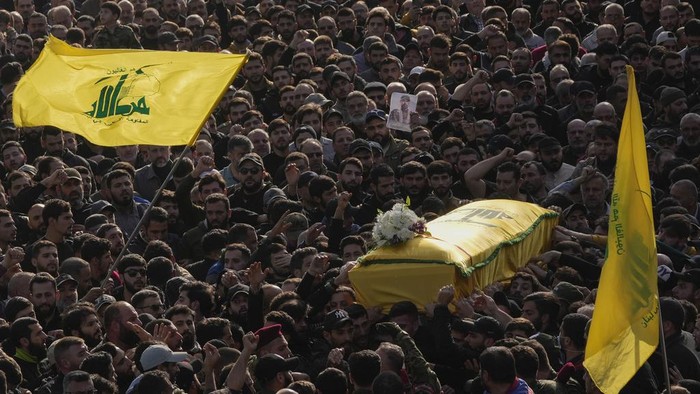 Mourners carry the coffin of senior Hezbollah commander Wissam al-Tawil during his funeral procession in the village of Khirbet Selm, south Lebanon, Tuesday, Jan. 9, 2024. The elite Hezbollah commander who was killed in an Israeli airstrike Monday in southern Lebanon fought for the group for decades and took part in some of its biggest battles. (AP Photo/Hussein Malla)