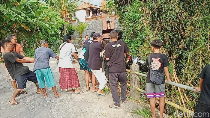 Warga mengevakuasi sepeda motor dari dalam jurang yang dibuang ODGJ di Gianyar, Bali.