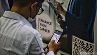 Seorang pengunjung melakukan scan barcode lowongan pekerjaan. 