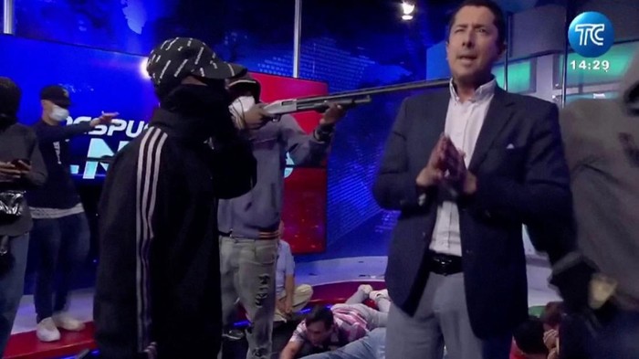 A hooded man points a gun at Ecuadorian TV presenter Jose Luis Calderon while on air inside Ecuador's TC television station, in Guayaquil, Ecuador, January 9, 2024, in this screen grab from video. Courtesy TC/Handout via REUTERS    THIS IMAGE HAS BEEN SUPPLIED BY A THIRD PARTY. NO RESALES. NO ARCHIVES. MANDATORY CREDIT
