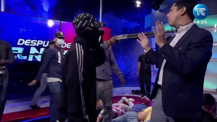 A hooded man points a gun at Ecuadorian TV presenter Jose Luis Calderon while on air inside Ecuador's TC television station, in Guayaquil, Ecuador, January 9, 2024, in this screen grab from video. Courtesy TC/Handout via REUTERS    THIS IMAGE HAS BEEN SUPPLIED BY A THIRD PARTY. NO RESALES. NO ARCHIVES. MANDATORY CREDIT