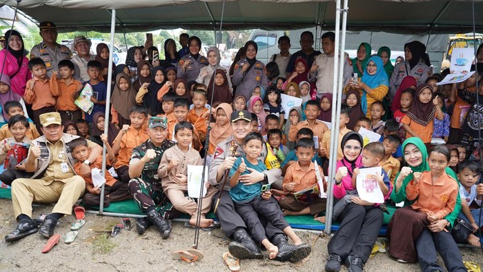 Kapolda Riau Irjen Mohammad Iqbal dan Danrem 031 Wira Bima Brigjen TNI Dany Rakca berfoto bersama usai menghibur dan bercengkerama dengan para anak-anak korban banjir. (Dok Humas Polda Riau)