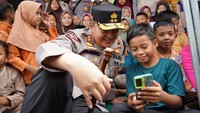 Foto: Kapolda Riau Irjen Mohammad Iqbal tampak bercengkerama dan menghibur para anak korban banjir agar tetap ceria. (Dok. Humas Polda Riau)