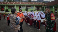 Petugas BPBD Agam dan anggota TNI membagikan masker untuk antisipasi abu vulkanik kepada pelajar SDN 12 Batang Silasiah, Nagari Bukik Batabuah, Agam. 